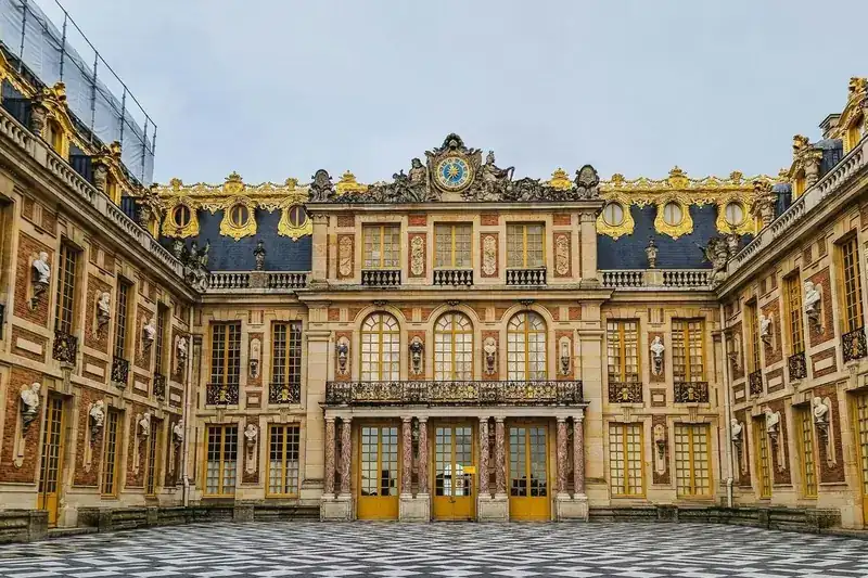 The gilded clock above the Marble Courtyard at the Palace of Versailles, open 9 AM Tuesday to Sunday